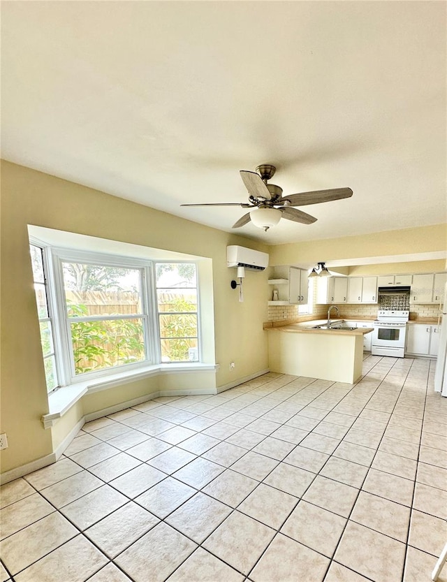 unfurnished living room with a wall mounted AC, light tile patterned flooring, sink, and ceiling fan