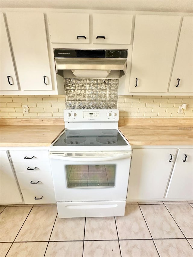 kitchen with backsplash, wood counters, light tile patterned flooring, and white electric range oven