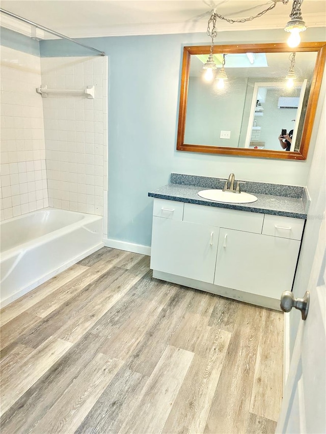 bathroom with tiled shower / bath, vanity, and hardwood / wood-style flooring