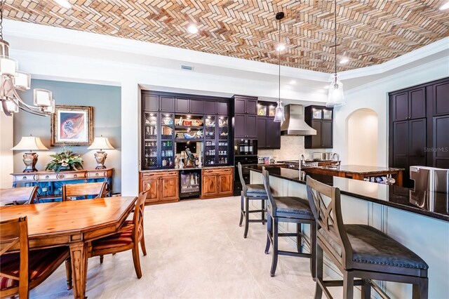 kitchen with a kitchen bar, wine cooler, custom exhaust hood, light tile patterned floors, and brick ceiling