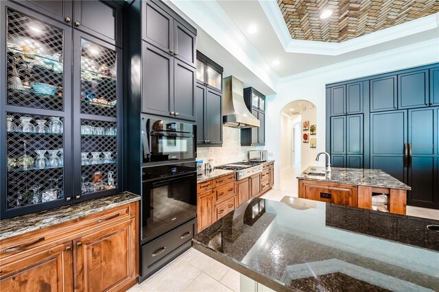 kitchen with custom range hood, light tile patterned floors, dark stone countertops, and black double oven