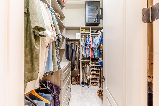 walk in closet with light tile patterned floors