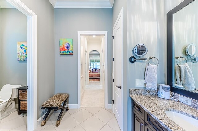 bathroom featuring tile patterned floors, crown molding, vanity, and toilet