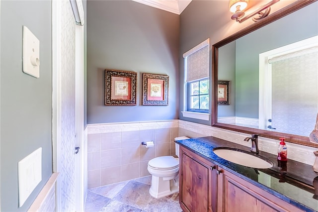 bathroom featuring vanity, crown molding, tile patterned floors, tile walls, and toilet