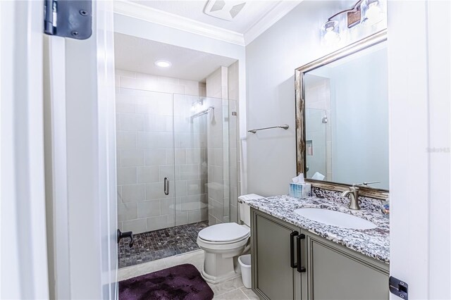 bathroom with ornamental molding, vanity, tile patterned flooring, toilet, and walk in shower