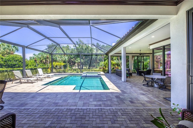 view of swimming pool featuring ceiling fan, a lanai, and a patio