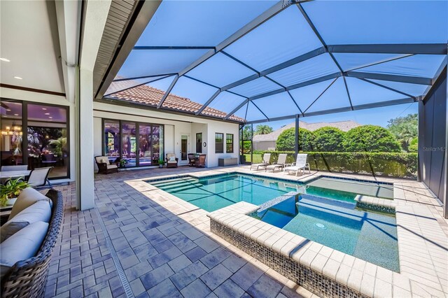 view of swimming pool featuring an in ground hot tub, a patio, and a lanai