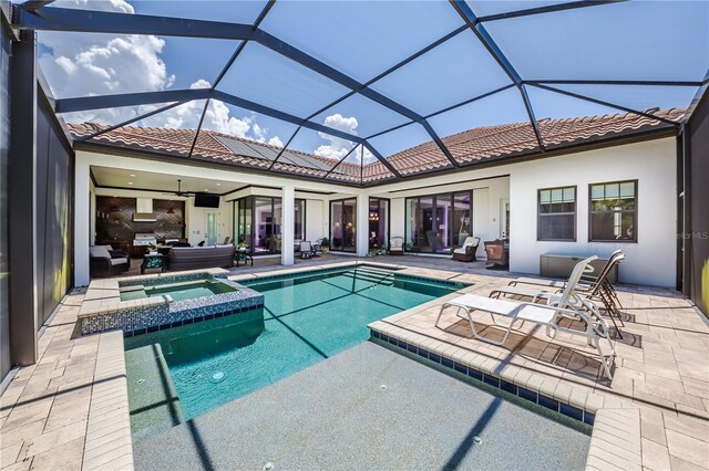 view of swimming pool with ceiling fan, a lanai, an in ground hot tub, and a patio area