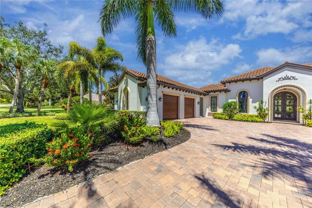 mediterranean / spanish house featuring french doors and a garage