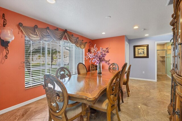 tiled dining area with a textured ceiling