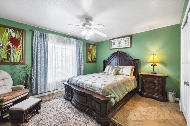 tiled bedroom featuring ceiling fan