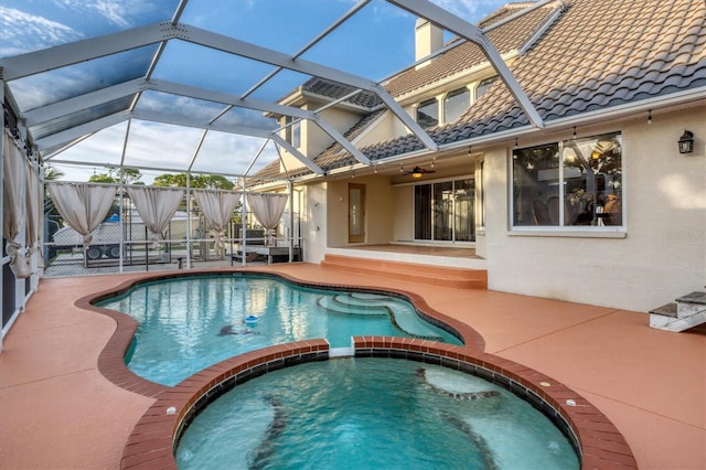 view of swimming pool with a lanai, an in ground hot tub, and a patio