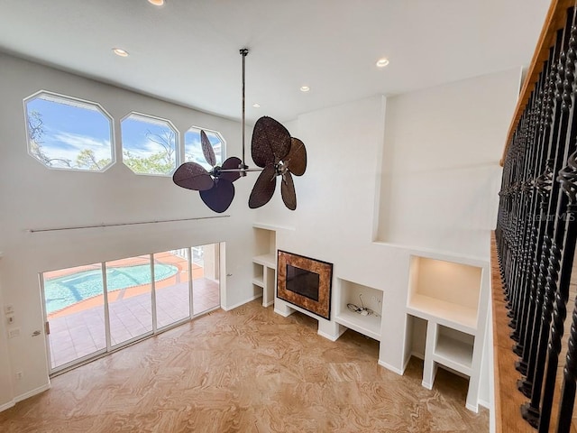 living area featuring baseboards, recessed lighting, a ceiling fan, and built in features