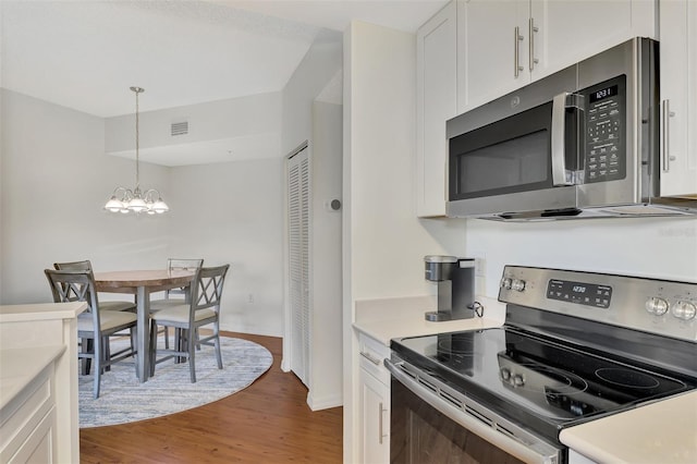 kitchen featuring an inviting chandelier, appliances with stainless steel finishes, dark wood-type flooring, white cabinetry, and hanging light fixtures