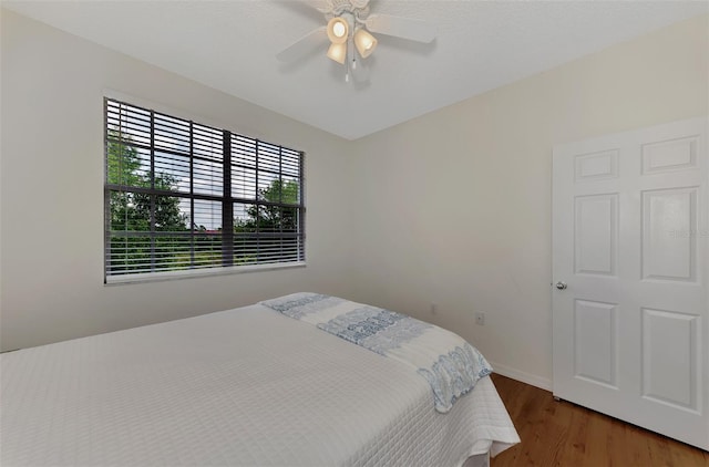 bedroom with ceiling fan and hardwood / wood-style flooring