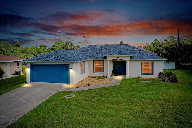 single story home with a lawn, cooling unit, and a garage