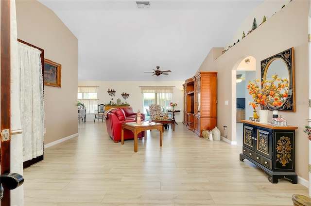 living room featuring ceiling fan, vaulted ceiling, and light wood-type flooring