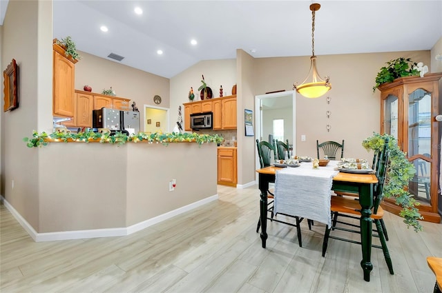 dining space with light hardwood / wood-style floors and lofted ceiling