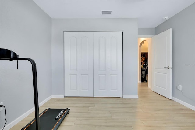 exercise room featuring light wood-type flooring