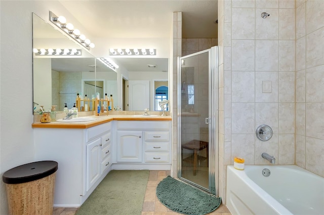 bathroom featuring plus walk in shower, double vanity, and tile patterned floors