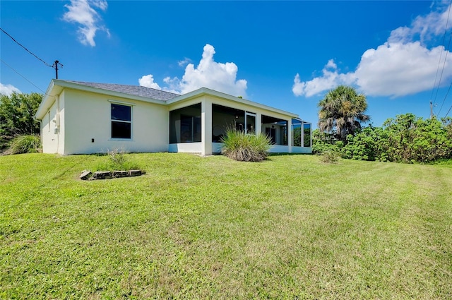 rear view of property with a lawn and a sunroom