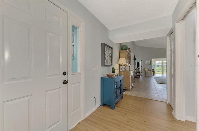 foyer entrance with light wood-type flooring and a textured ceiling