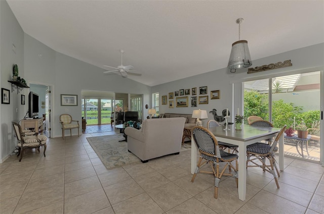 dining space with ceiling fan, light tile patterned floors, and high vaulted ceiling