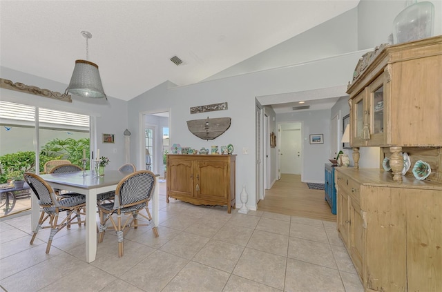 tiled dining room with high vaulted ceiling