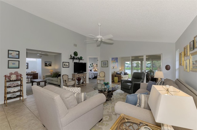 living room featuring a textured ceiling, lofted ceiling, light tile patterned flooring, and ceiling fan