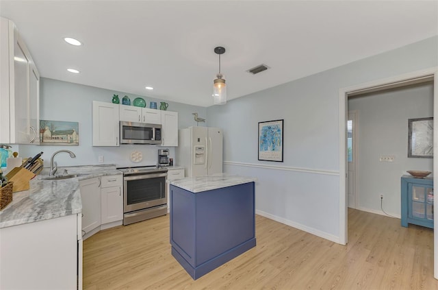 kitchen featuring sink, a kitchen island, stainless steel appliances, white cabinets, and hanging light fixtures