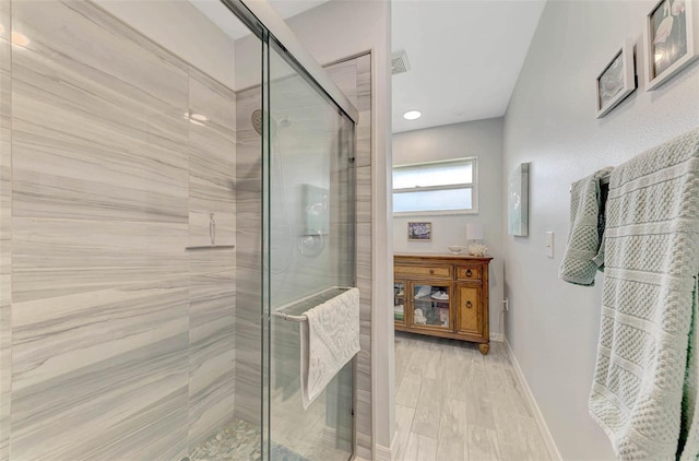 bathroom with hardwood / wood-style flooring and an enclosed shower