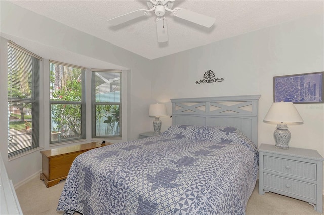 carpeted bedroom with ceiling fan and a textured ceiling