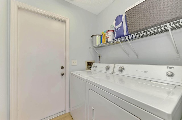 laundry room with washer and dryer and a textured ceiling