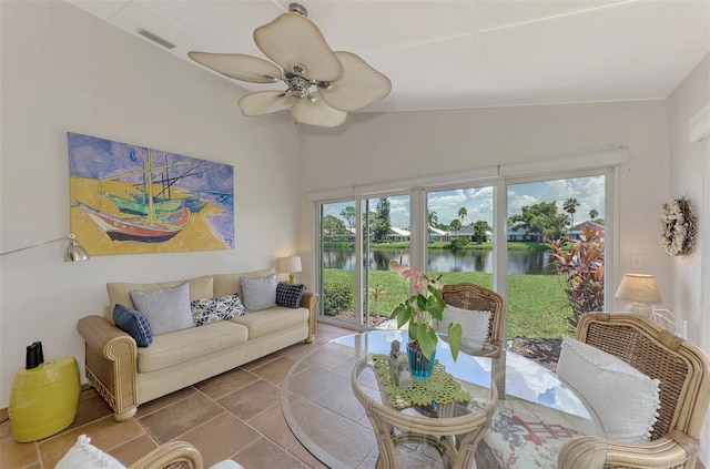 living room with ceiling fan, a water view, and a healthy amount of sunlight