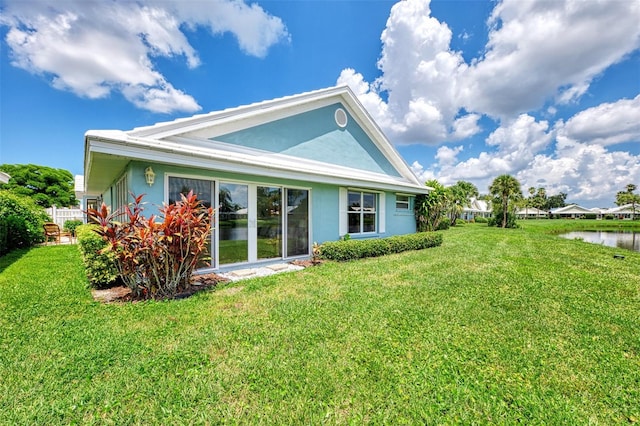 back of property featuring a yard and a water view