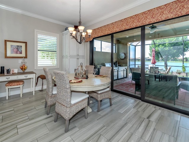 dining area with ceiling fan with notable chandelier, crown molding, and a water view