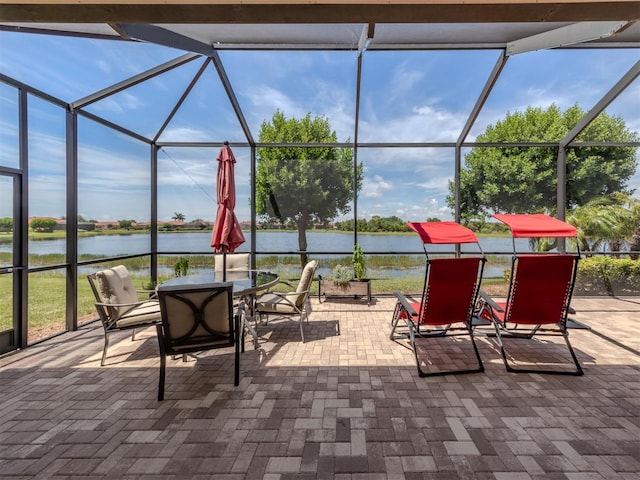 view of patio / terrace featuring a lanai and a water view