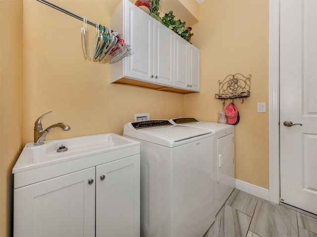 washroom with washer and dryer, light tile patterned floors, sink, and cabinets