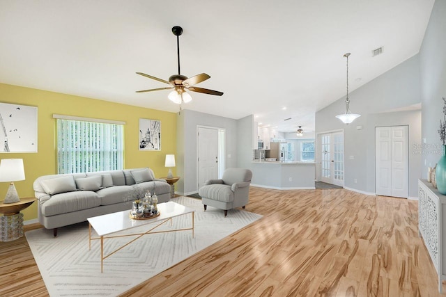 living room with ceiling fan, a wealth of natural light, light hardwood / wood-style floors, and french doors