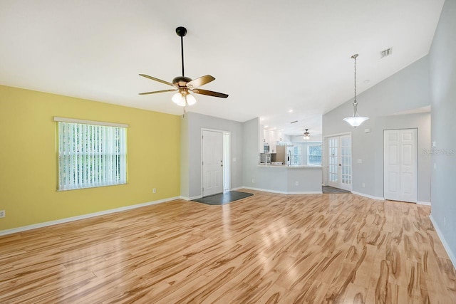 unfurnished living room featuring light hardwood / wood-style flooring, ceiling fan, a healthy amount of sunlight, and french doors