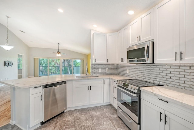 kitchen featuring vaulted ceiling, appliances with stainless steel finishes, kitchen peninsula, sink, and ceiling fan