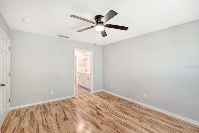 unfurnished bedroom featuring a textured ceiling, light hardwood / wood-style flooring, ceiling fan, and ensuite bathroom