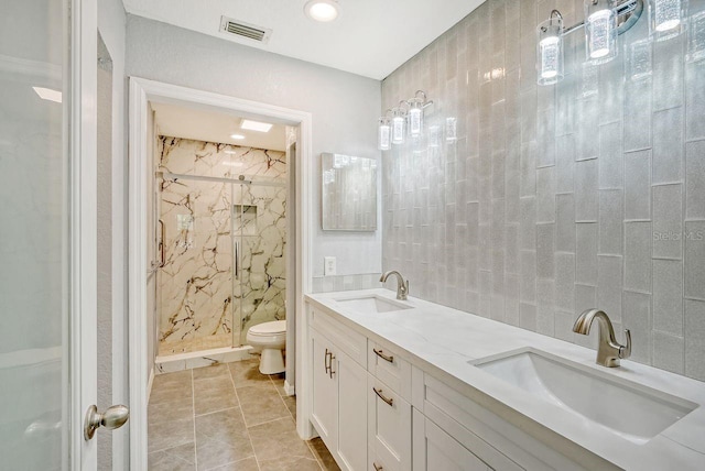 bathroom featuring tiled shower, vanity, toilet, and plenty of natural light