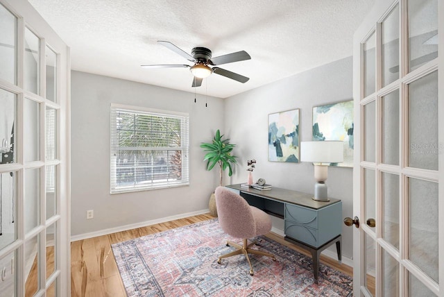 office area featuring light wood-type flooring, ceiling fan, a textured ceiling, and french doors