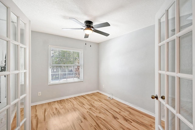 unfurnished room with light wood-type flooring, french doors, a textured ceiling, and ceiling fan