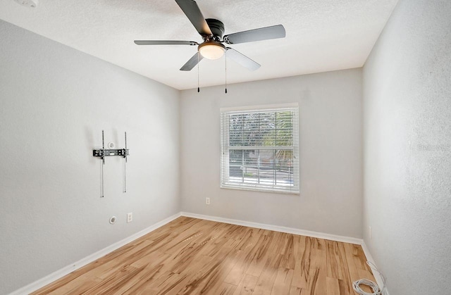 spare room featuring ceiling fan, light hardwood / wood-style floors, and a textured ceiling