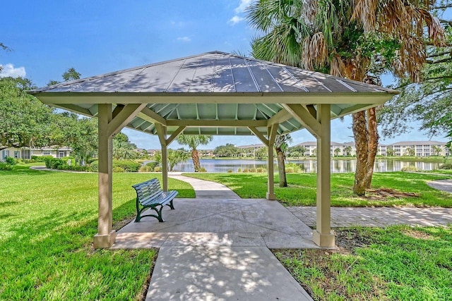 surrounding community with a gazebo, a lawn, and a water view