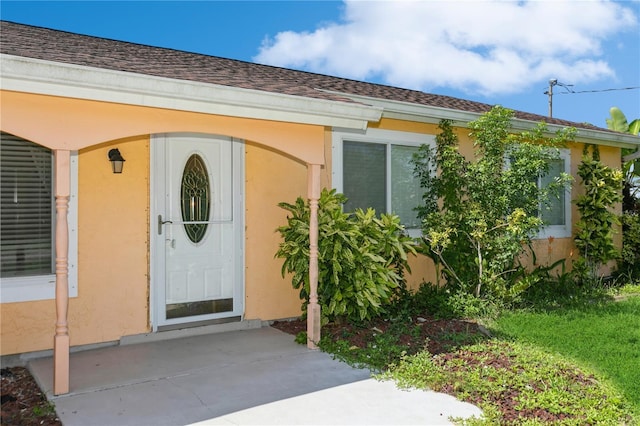 18069 Ohara Dr, Port Charlotte, FL 33948 - view of exterior entry featuring roof with shingles and stucco siding