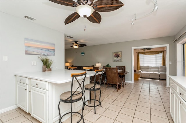 kitchen featuring kitchen peninsula, white cabinetry, and ceiling fan