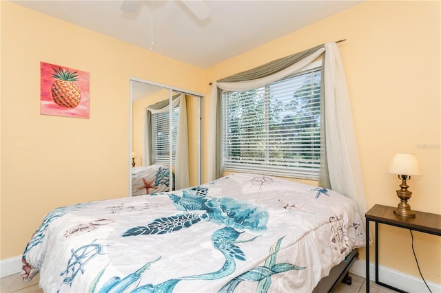 bedroom with tile patterned flooring, ceiling fan, and a closet